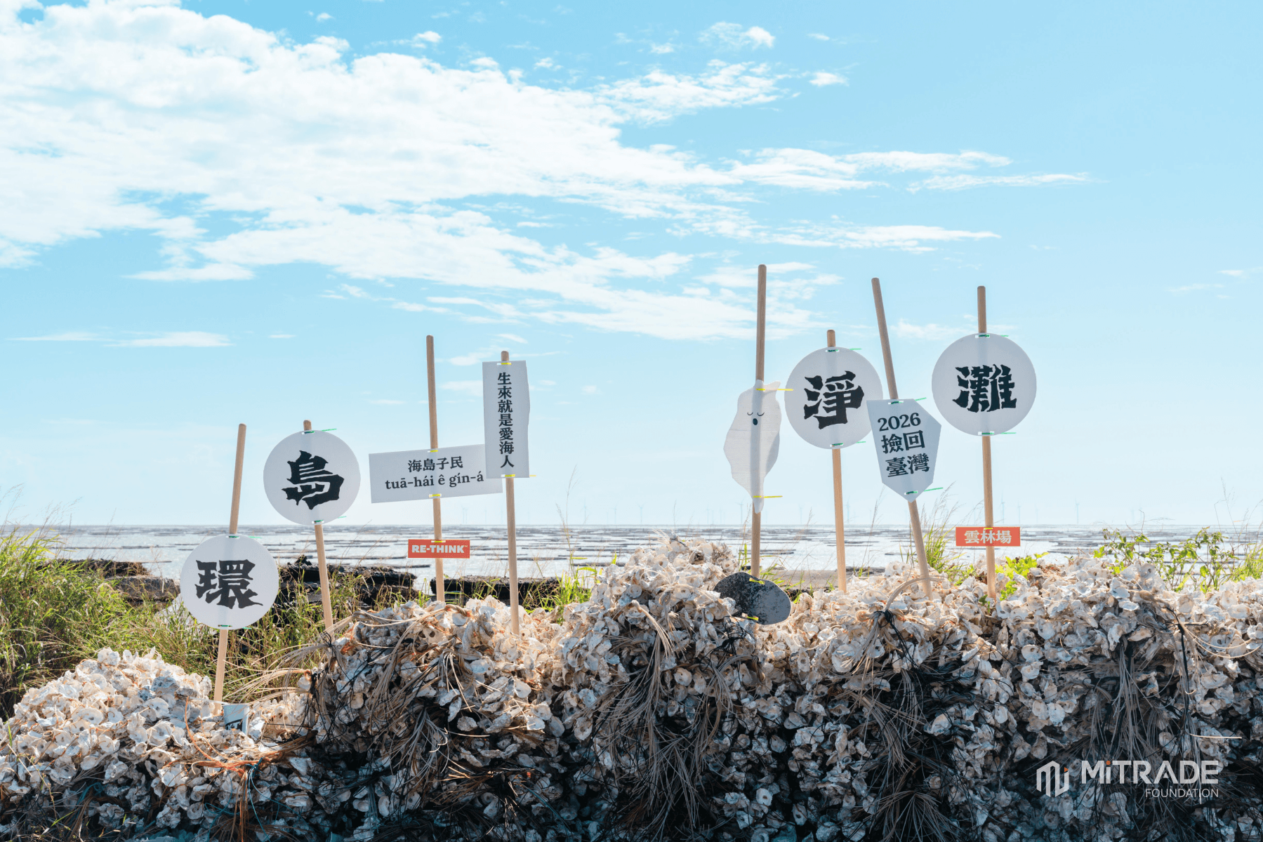 RE-THINK educational signs standing above marine debris on the coast