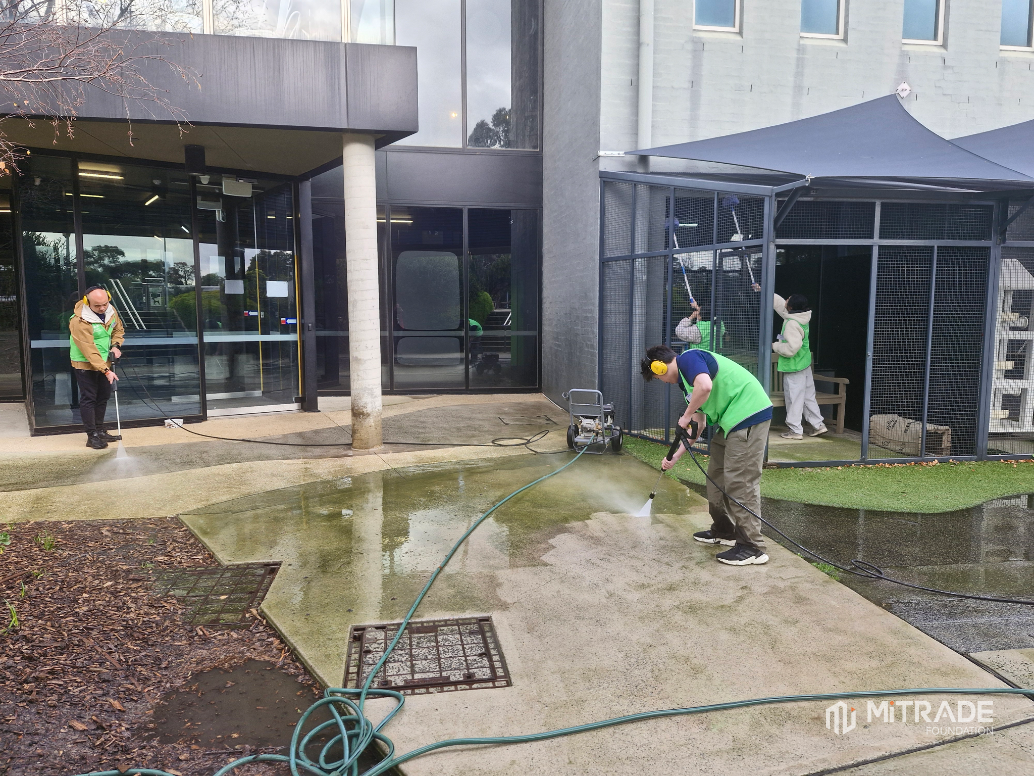 Volunteers washing outdoor animal enclosures at the shelter